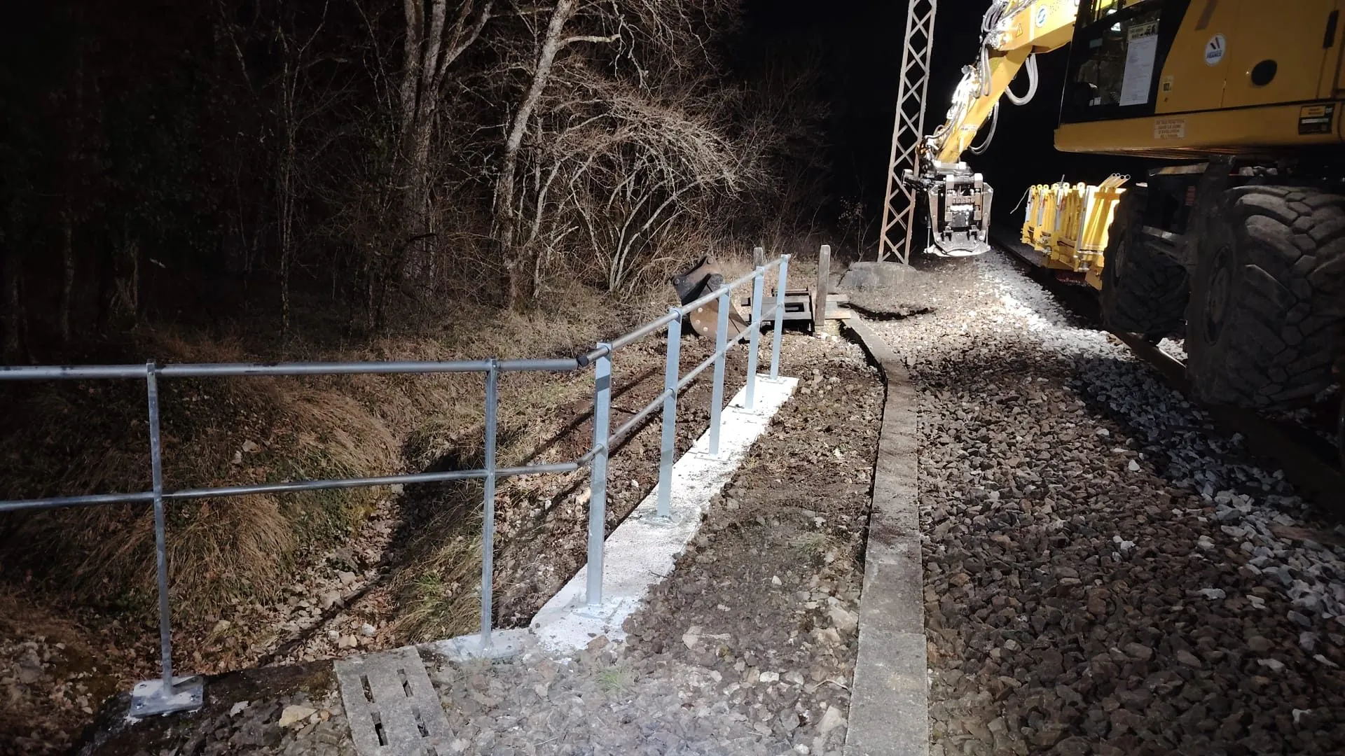 Chantier de nuit sécurisé avec pelle rail-route